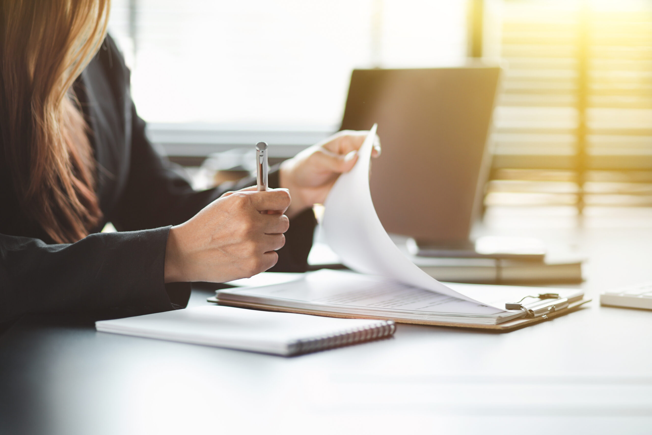 Close up of Accounting businesswoman working on note laptop computer and analyzing real estate investment data, Financial and tax systems concept.